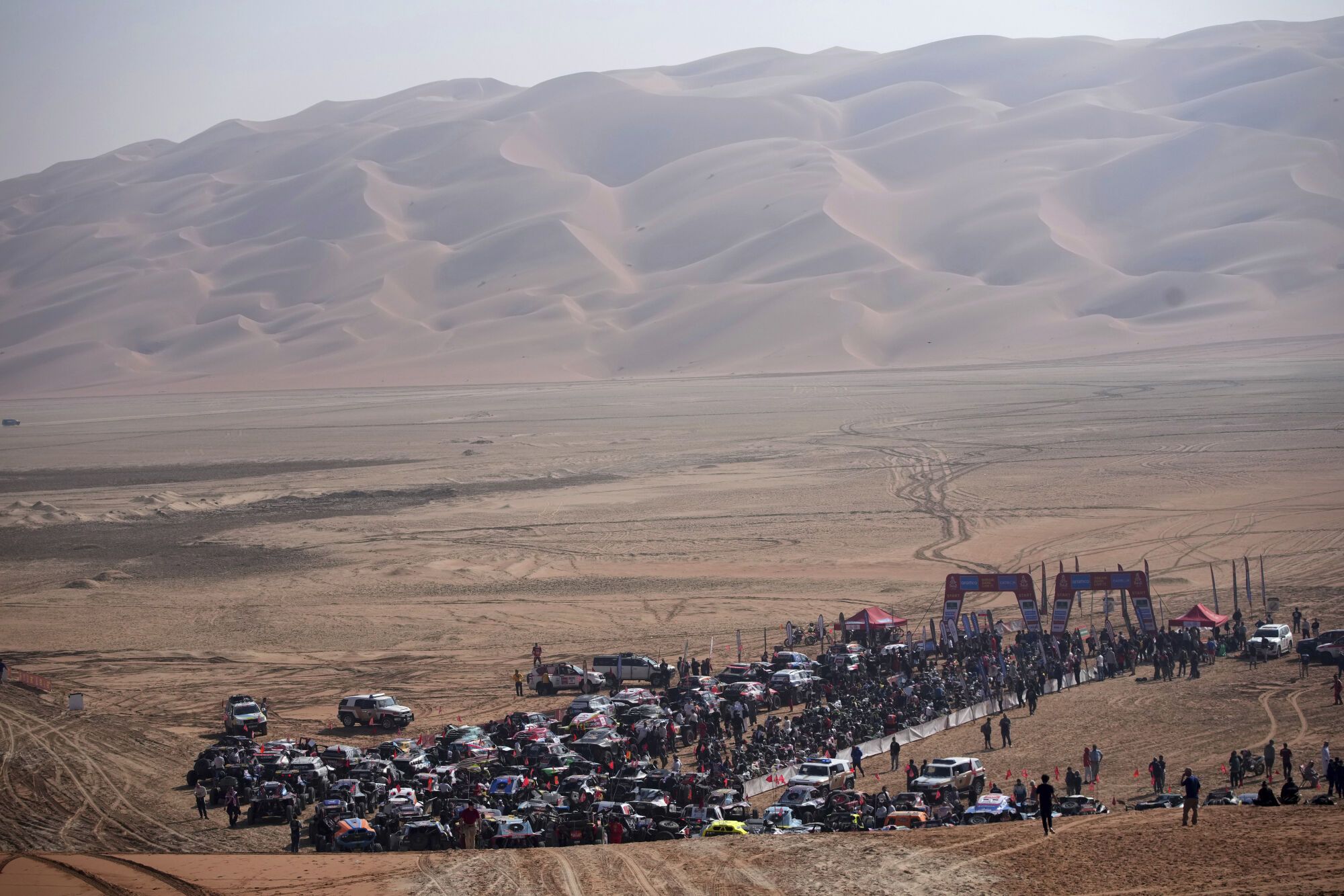 Competitors gather at the start delayed due to fog during the eleventh stage of the Dakar Rally with start and finish in Shubaytah, Saudi Arabia, Thursday, Jan. 16, 2025. (AP Photo/Christophe Ena)