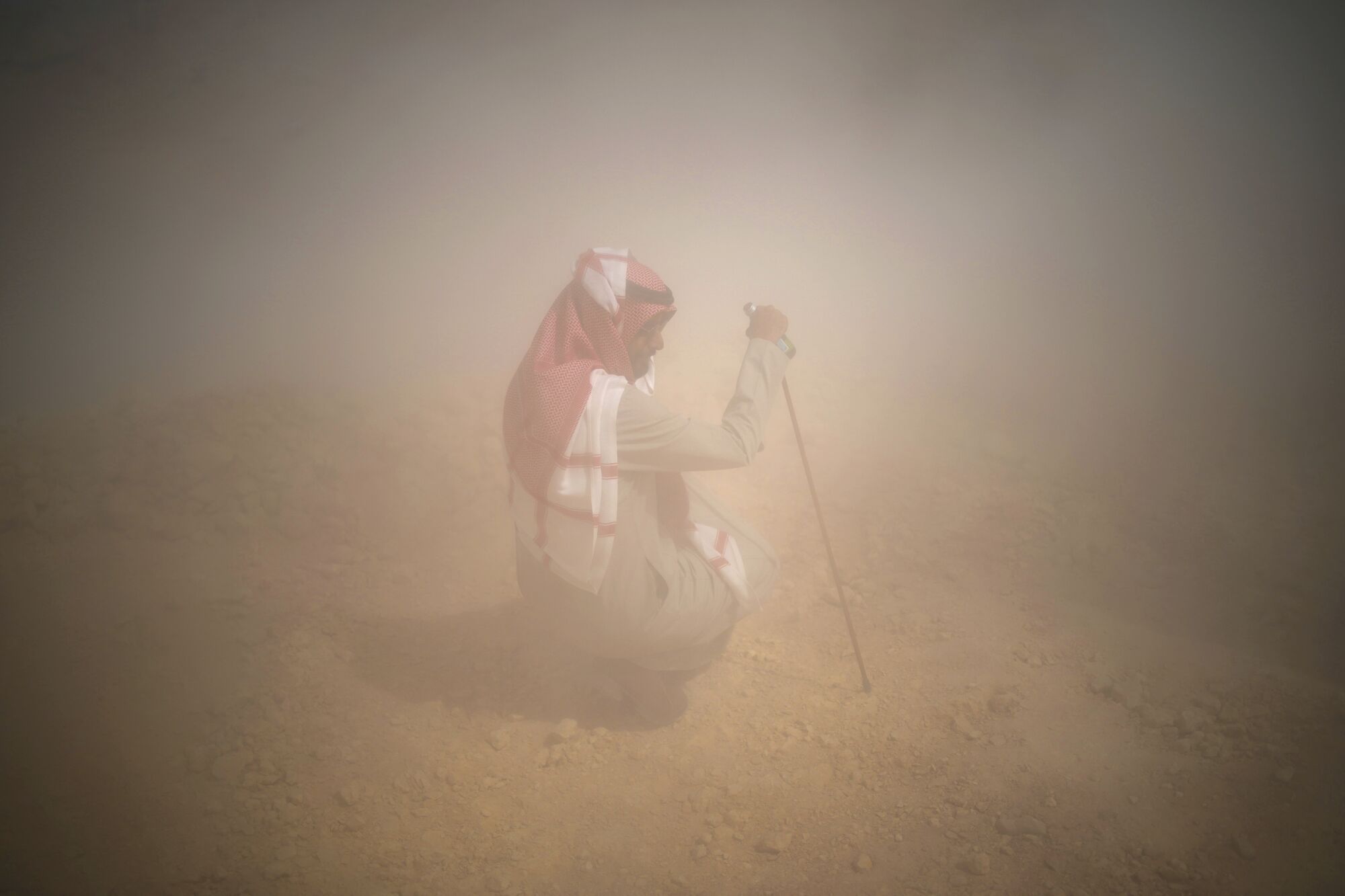 A man protects himself from dust during the ninth stage of the Dakar Rally between Riyadh and Haradh, Saudi Arabia, Tuesday, Jan. 14, 2025. (AP Photo/Christophe Ena) Associated Press/LaPresse. EDITORIAL USE ONLY/ONLY ITALY AND SPAIN