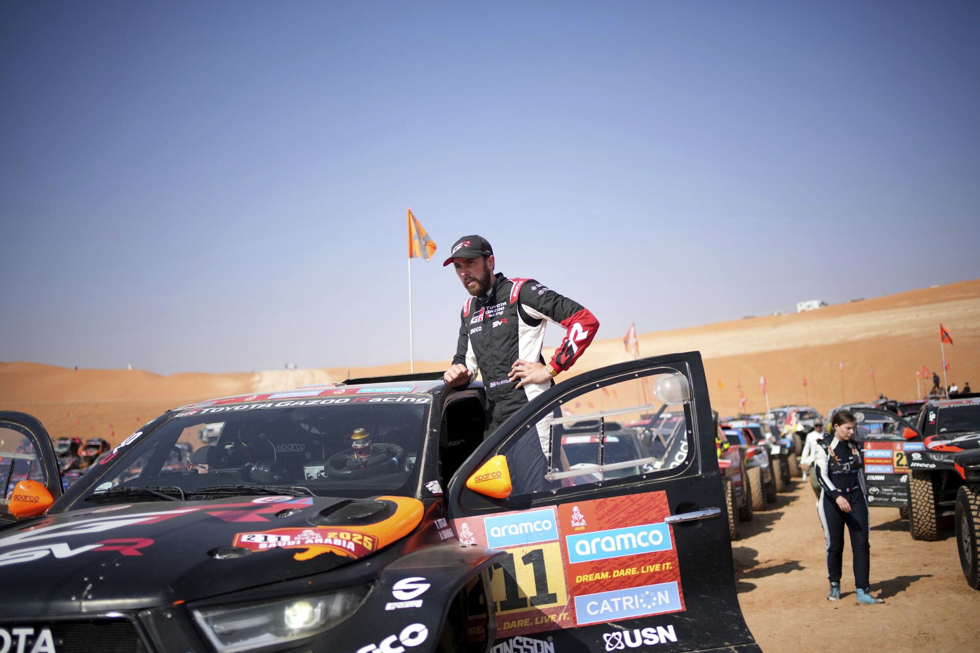Driver Henk Lategan waits at the start delayed due to fog during the eleventh stage of the Dakar Rally with start and finish in Shubaytah, Saudi Arabia, Thursday, Jan. 16, 2025. (AP Photo/Christophe Ena)