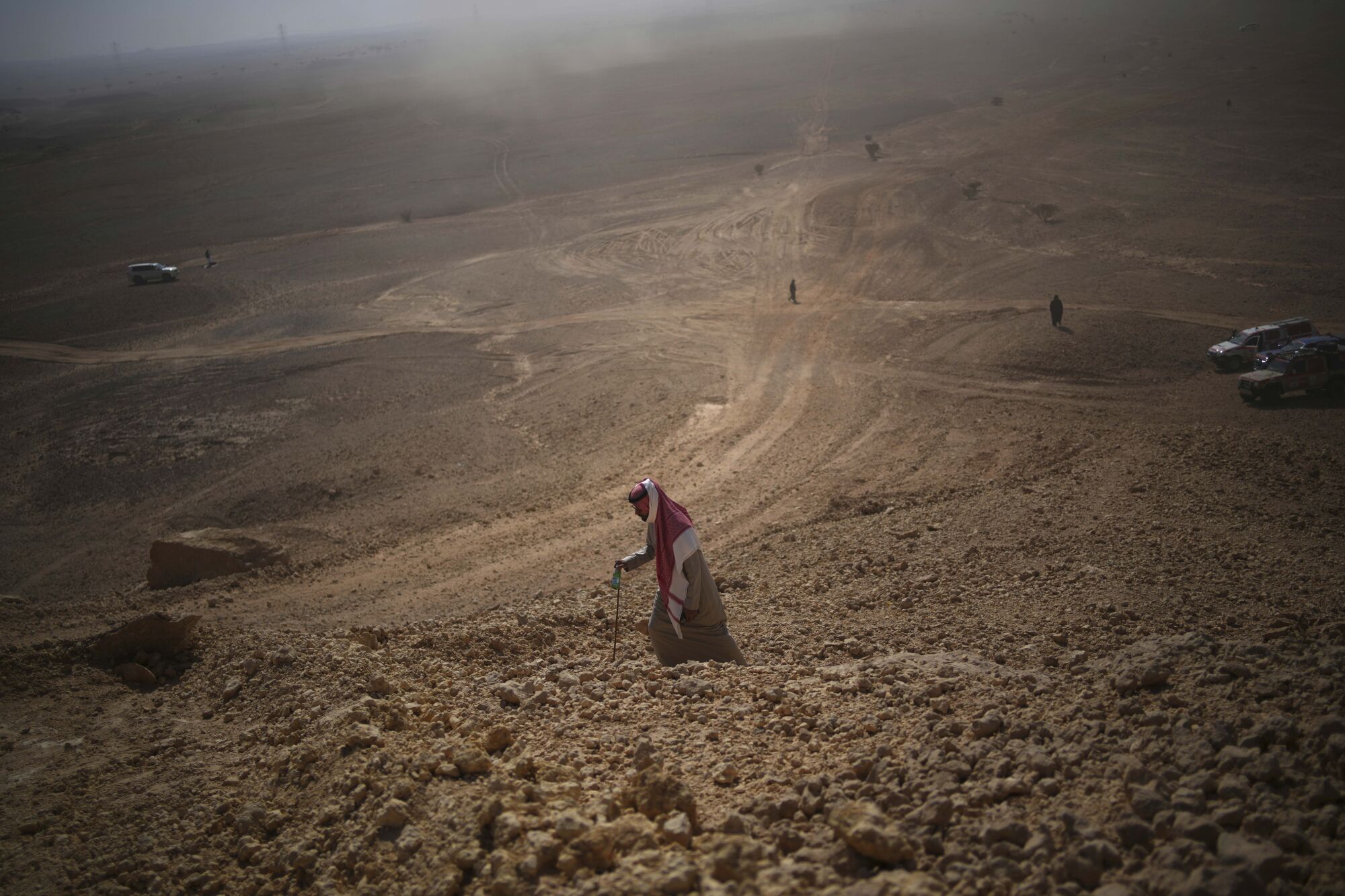 A man climbs to watch the drivers during the ninth stage of the Dakar Rally between Riyadh and Haradh, Saudi Arabia, Tuesday, Jan. 14, 2025. (AP Photo/Christophe Ena) Associated Press/LaPresse. EDITORIAL USE ONLY/ONLY ITALY AND SPAIN