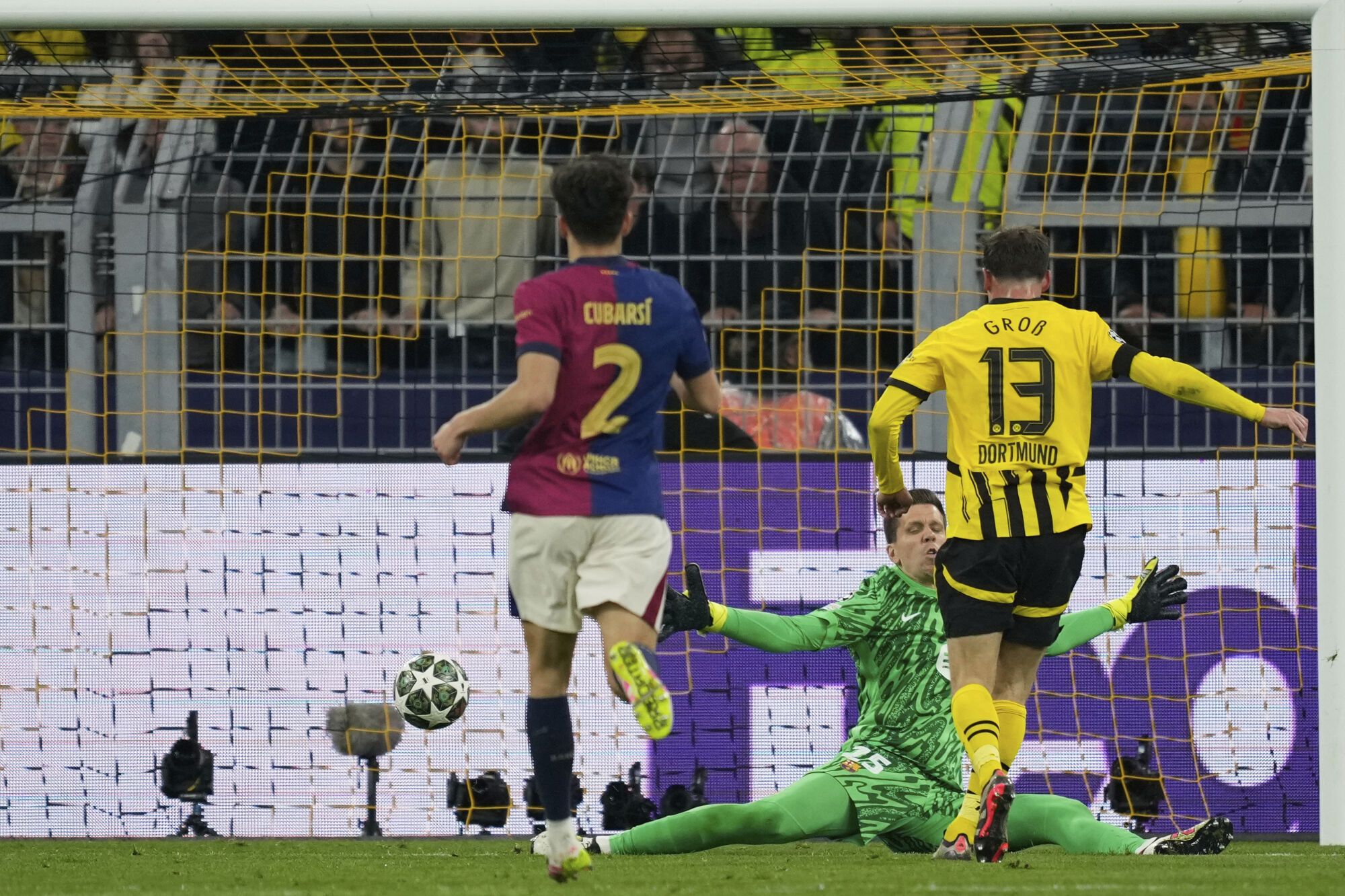 Dortmund's Pascal Gross, right, scores a disallowed goal during the Champions League quarterfinals second leg soccer match between Borussia Dortmund and Barcelona, at the Signa-Iduna Park in Dortmund, Germany, Tuesday, April 15, 2025. (AP Photo/Martin Meissner). EDITORIAL USE ONLY/ONLY ITALY AND SPAIN
