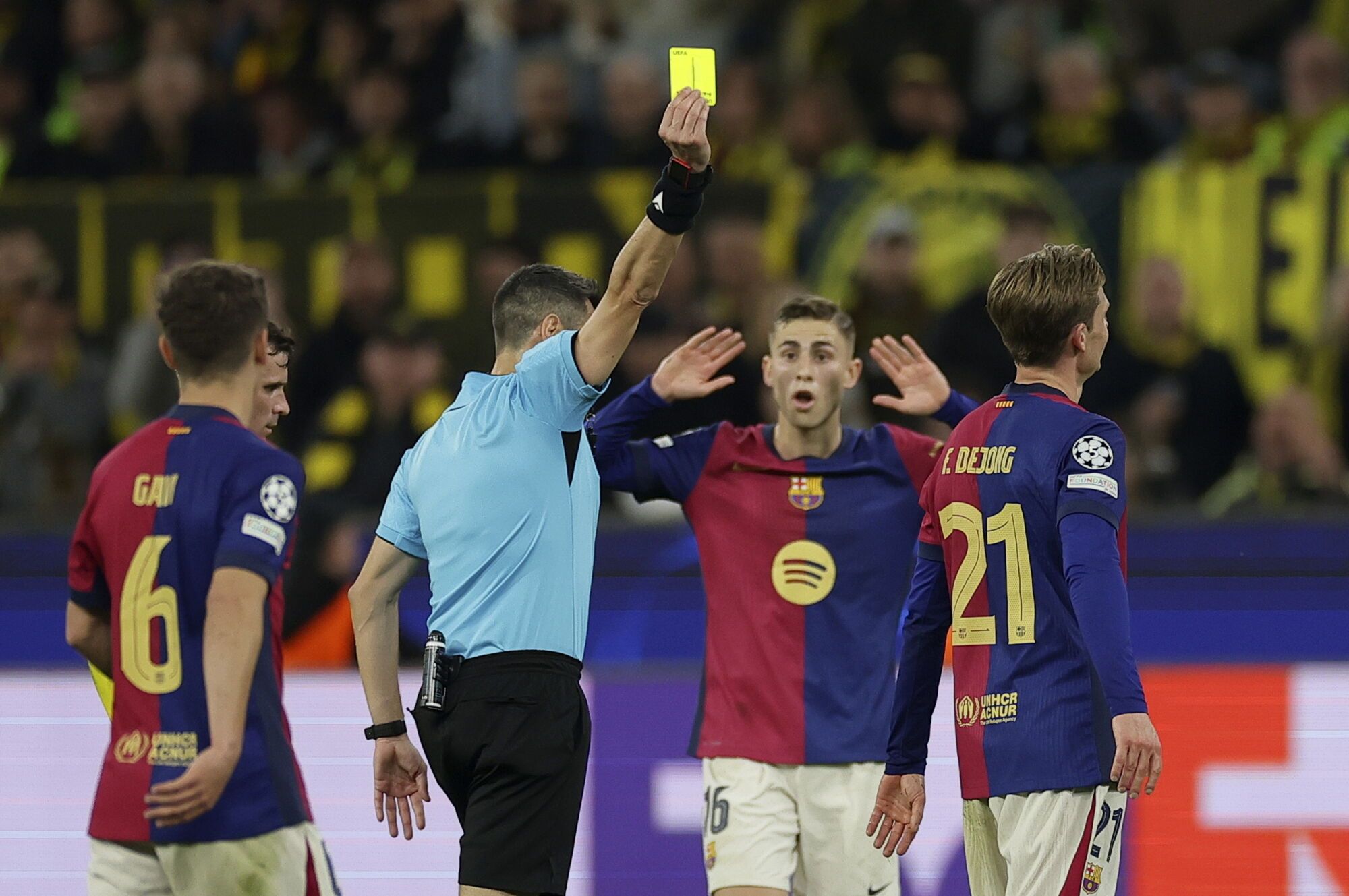 DORTMUND (Germany), 15/04/2025.- Frenkie de Jong of Barcelona (R) receives a yellow card from referee Maurizio Mariani during the UEFA Champions League quarter-finals, 2nd leg soccer match between Borussia Dortmund and FC Barcelona, in Dortmund, Germany, 15 April 2025. (Liga de Campeones, Alemania) EFE/EPA/CHRISTOPHER NEUNDORF