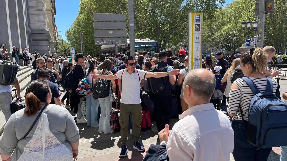 Un guía trata de mediar en el caos formado para subir al bus del aeropuerto