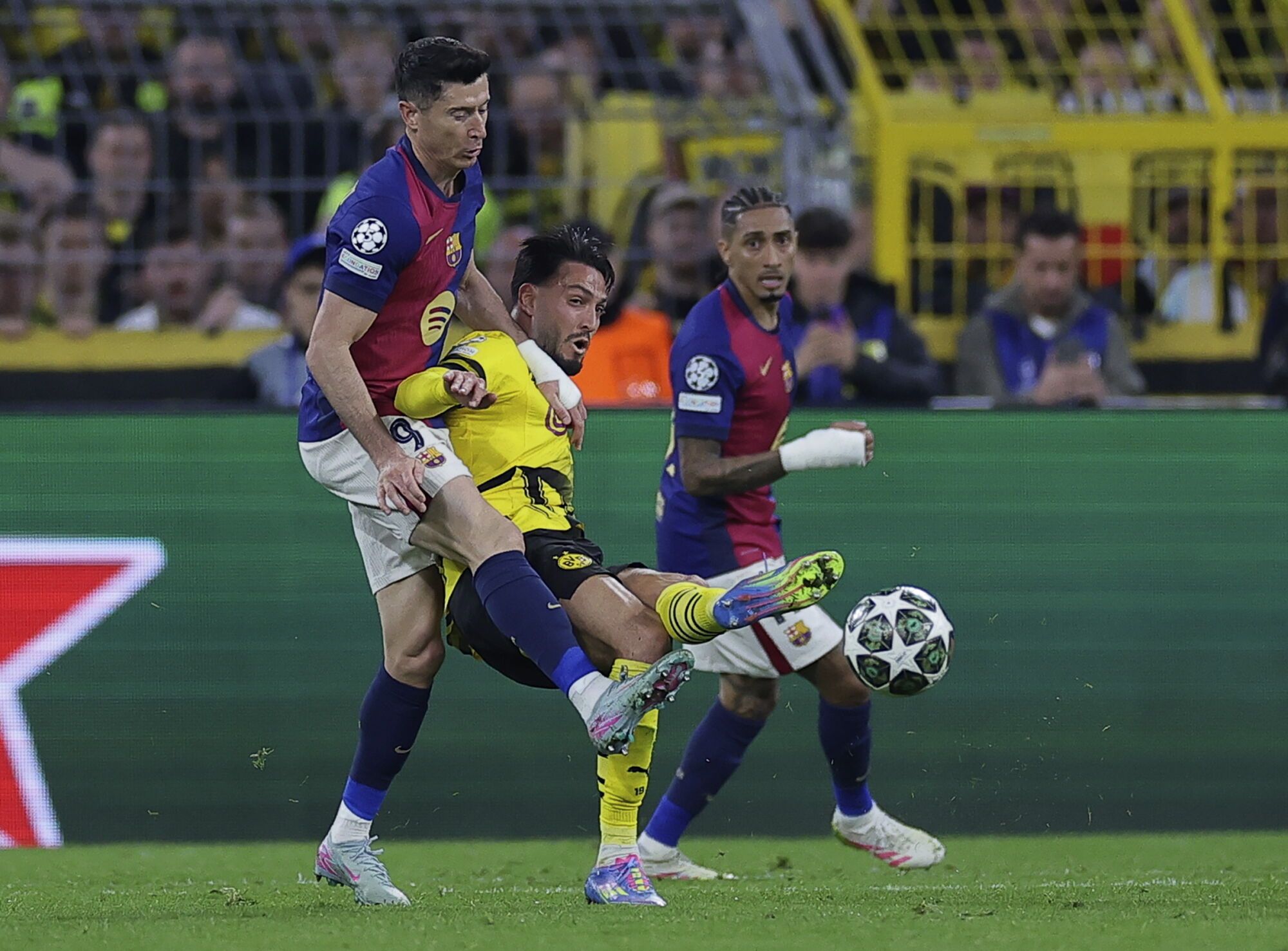 DORTMUND (Germany), 15/04/2025.- Ramy Bensebaini of Dortmund (R) and Robert Lewandowski of Barcelona (L) in action during the UEFA Champions League quarter-finals, 2nd leg soccer match between Borussia Dortmund and FC Barcelona, in Dortmund, Germany, 15 April 2025. (Liga de Campeones, Alemania) EFE/EPA/CHRISTOPHER NEUNDORF