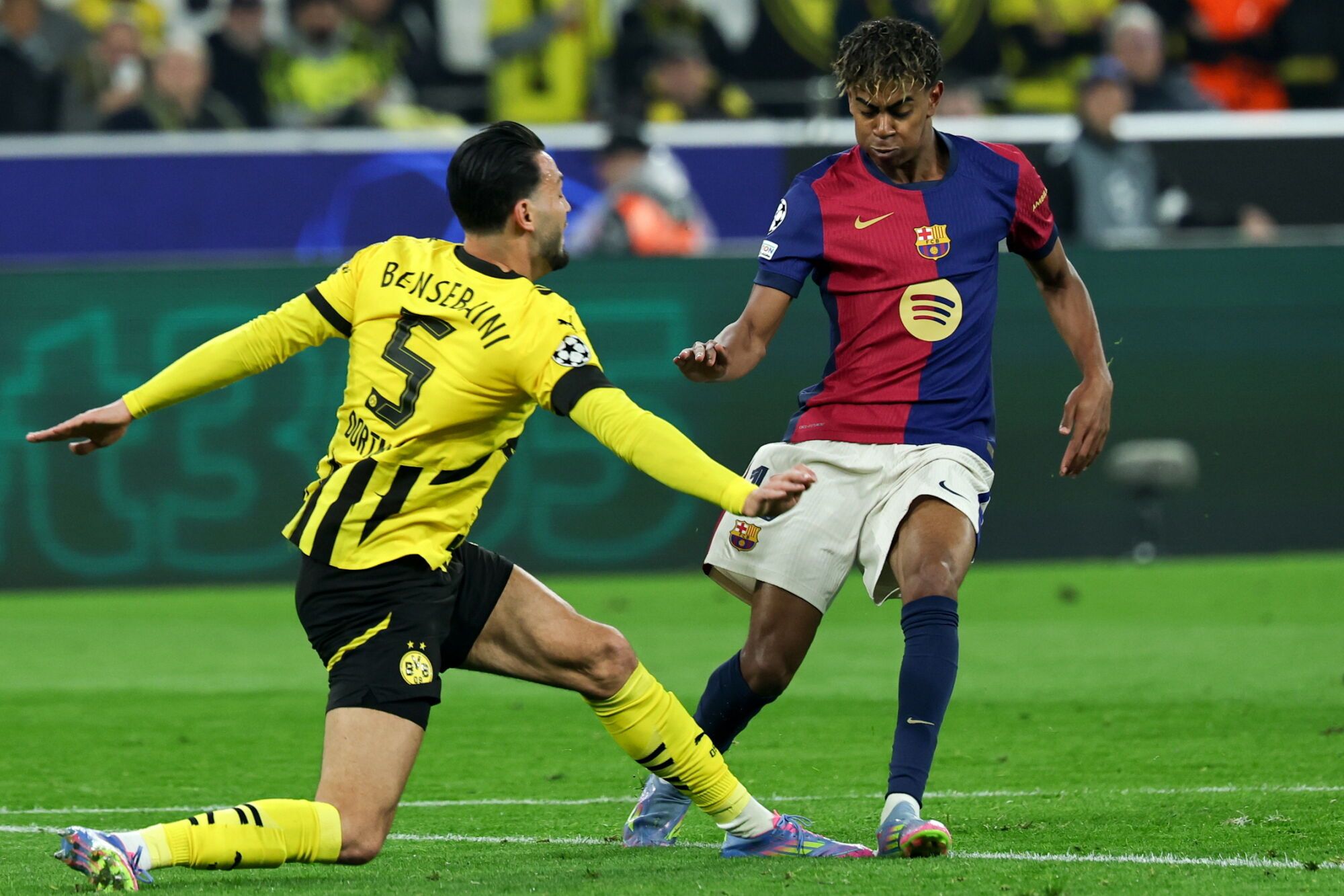 Dortmund (Germany), 15/04/2025.- Lamine Yamal (C) of Barcelona in action against Ramy Bensebaini (L) of Dortmund during the UEFA Champions League quarter-finals, 2nd leg soccer match between Borussia Dortmund and FC Barcelona, in Dortmund, Germany, 15 April 2025. (Liga de Campeones, Alemania) EFE/EPA/FRIEDEMANN VOGEL