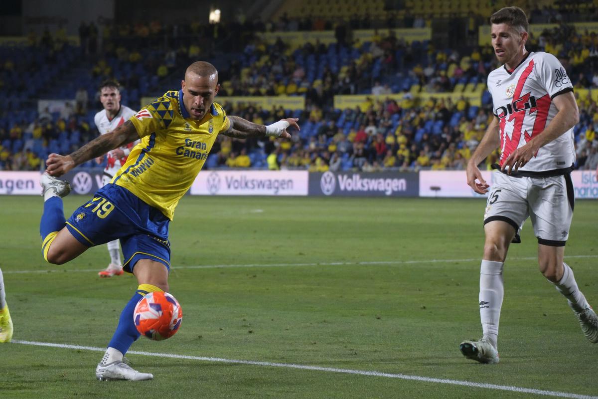 LAS PALMAS DE GRAN CANARIA, 09/05/2025.- El delantero de la UD Las Palmas, Sandro Ramírez (i), se dispone a golpear el balón ante el centrocampista del Rayo Vallecano, Gerard Gumbau, durante el encuentro correspondiente a la jornada 35 de Laliga EA Sports que disputan hoy viernes Las Palmas y Rayo en el Estadio de Gran Canaria. EFE / Angel Medina G.